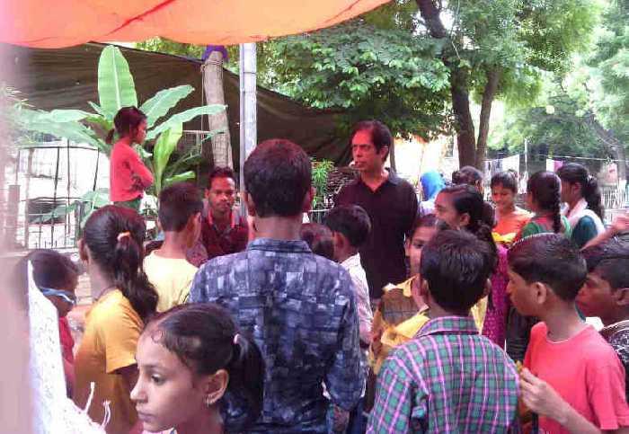 Rakesh Raman explaining the benefits of modern alternative education to people in a street of Delhi during RMN Foundation’s education awareness campaigns.