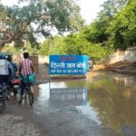 Neglected Delhi Jal Board repair site with hazardous mud and signage.